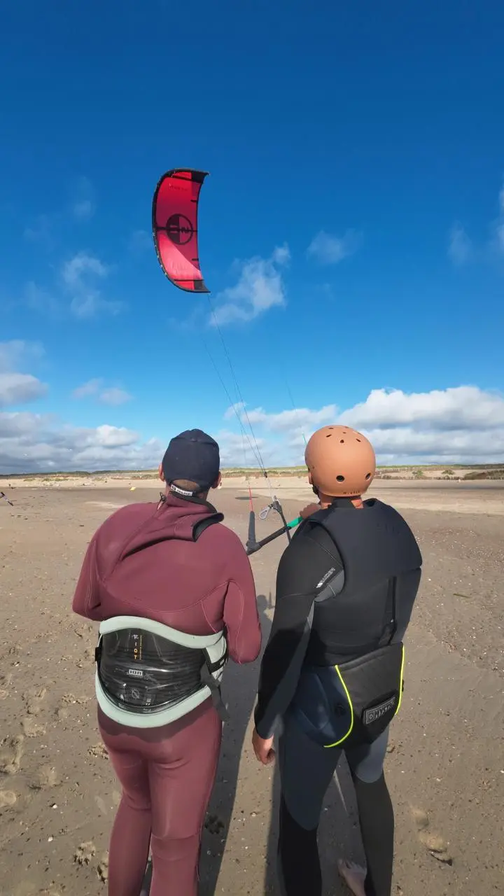 Kitesurfing lesson at Brouwersdam — instructor and student on the beach